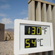 A digital thermometer showing a temperature of 130 in the desert.